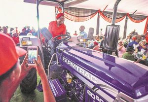 Blou Farmtrac-trekker wat EFF aan swart boere geskenk het “om grond te bewerk” staan en stof vergaar by Polokwane lodge